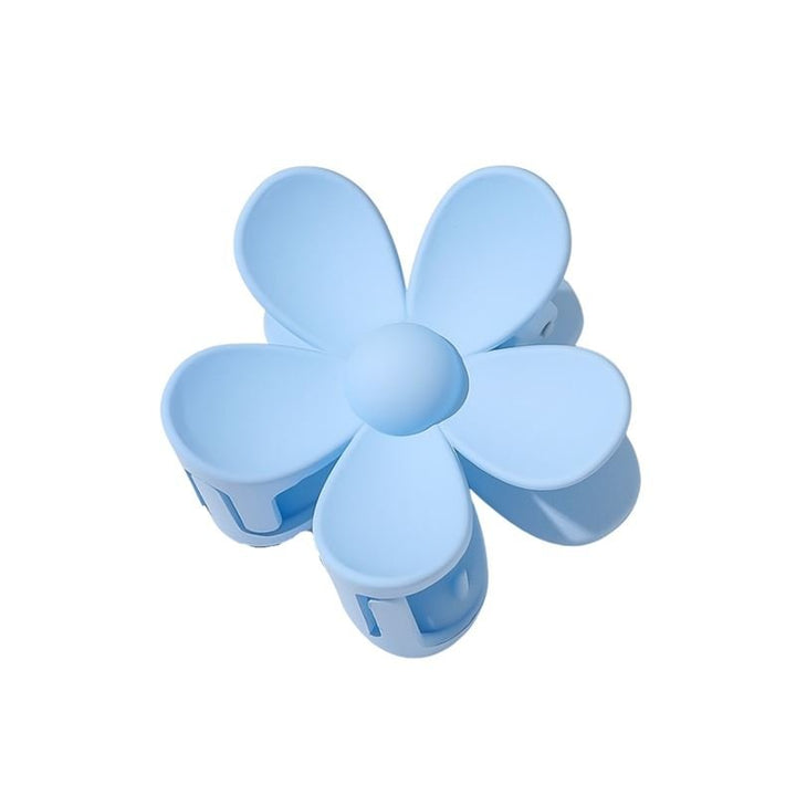 The SOHO Bloom Hair Claw in light blue features a smooth finish and rounded five-petal flower design, shown from above.