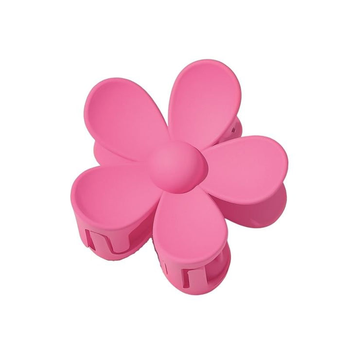 The SOHO Bloom Hair Claw - Pink by SOHO features a cute six-petal pink flower design with a central button, shown from above on a plain white background.