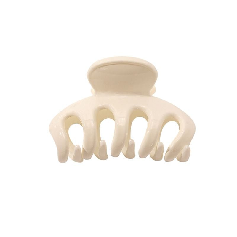 The SOHO Esta Hair Claw - White by SOHO is a small, cream-colored plastic clip with five rounded prongs for extra grip, ideal for secure hairstyling. Shown against a plain white background.