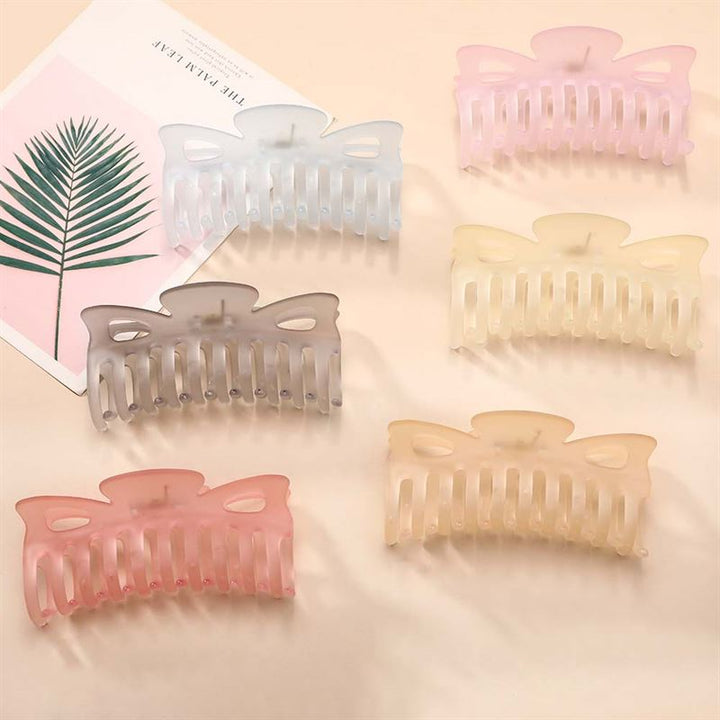 The SOHO Jelly Hair Claw - Cool Blue by SOHO offers a strong grip for all hair types. Shown on a light surface with minimalist decor, it features a soft blue pastel hue perfect for secure, stylish holds.