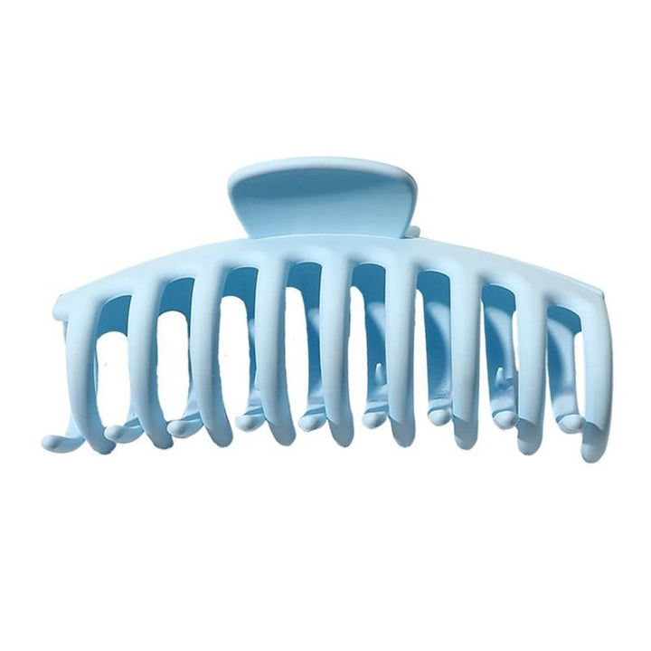 The SOHO Kana Hair Claw in light blue features wide, curved teeth for a strong grip and suits all hair types. Shown against a white background.