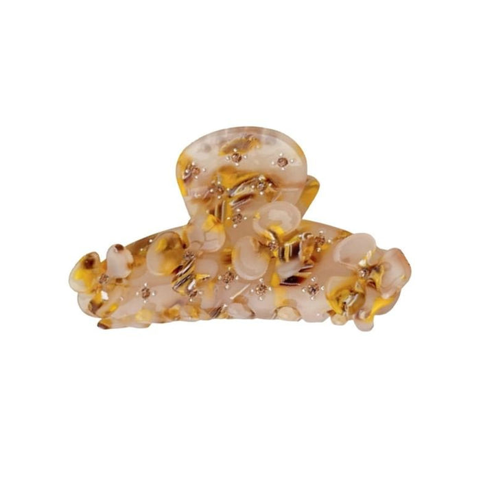 The SOHO Posy Hair Claw - Cider by SOHO features a beige and yellow marbled design with an irregular, glossy finish and decorative spots—an elegant accessory to elevate any hairstyle.